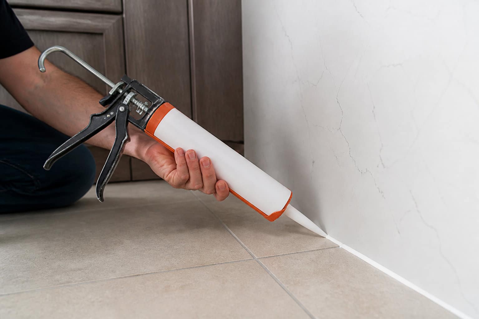 Application d'un joint de silicone au mur pour boucher un accès aux cafards